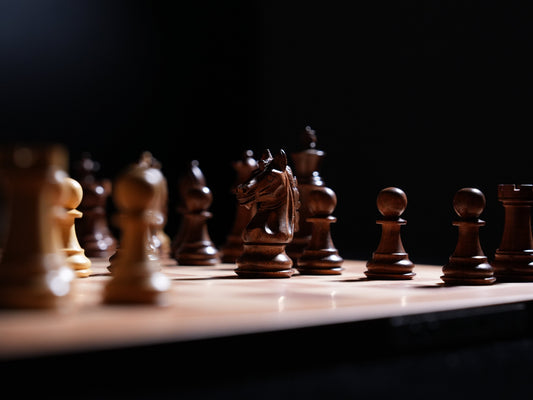 A close-up of a chessboard showcasing wooden pieces, symbolizing the strategy of defending difficult positions.
