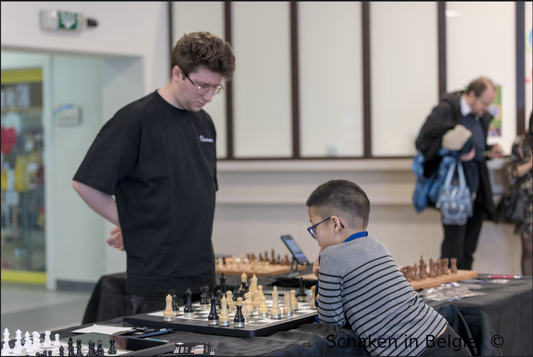 Belgian Youth Championship players strategizing over a chessboard at the event.