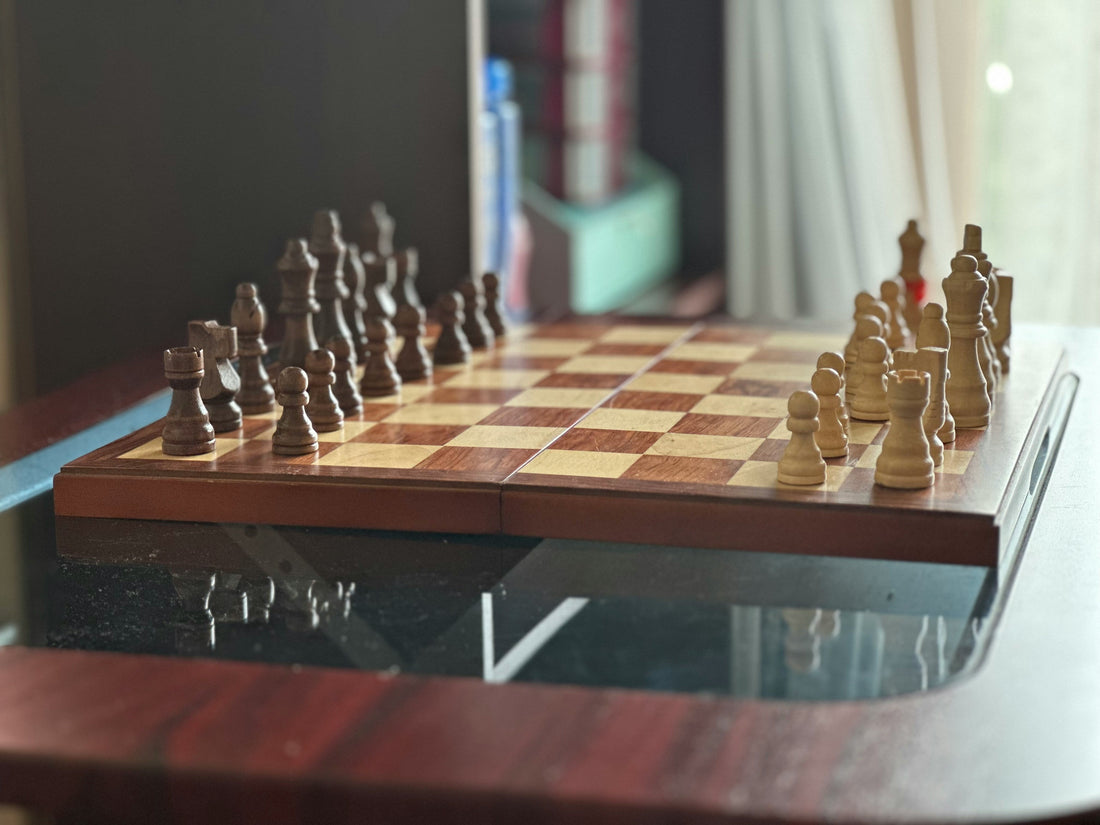 A chess game setup with brown and beige pieces on a wooden chessboard, ready for strategic play.