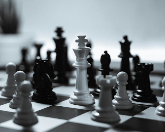 A classic chess game in black and white, showcasing strategic attacking moves on a chessboard.