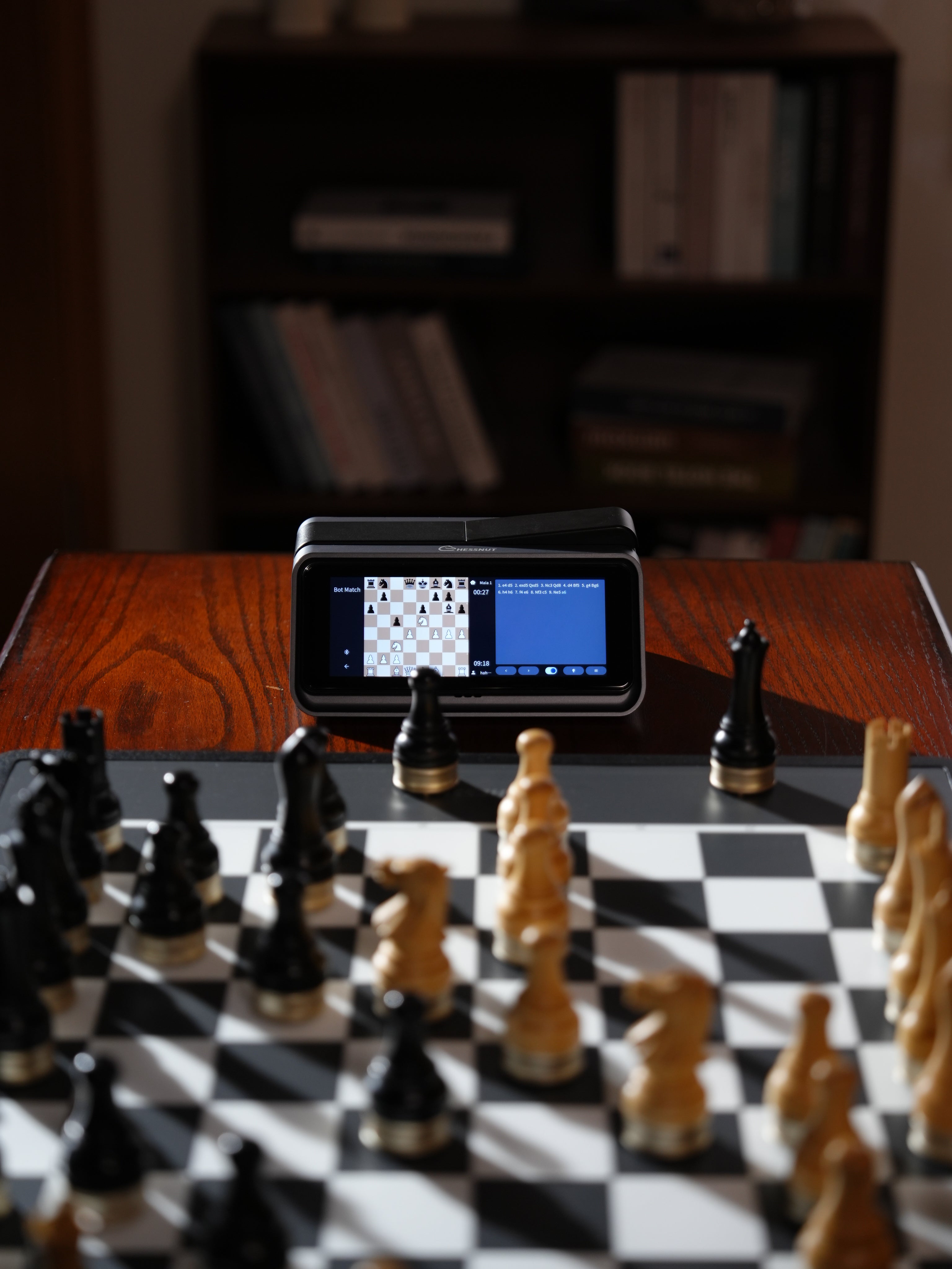 	Chessnut Companion smart AI chess clock beside a wooden chessboard